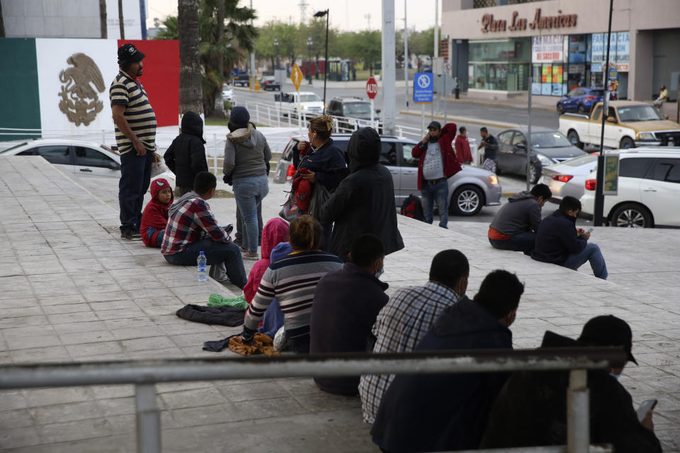 Migrants recently expelled from the U.S. after trying to seek asylum sit next to the international bridge in the Mexican border city of Reynosa, Saturday, March 27, 2021. Dozens of migrants who earlier tried to cross into the U.S. in order to seek asylum have been expelled from the U.S. under pandemic-related presidential authority. (AP Photo/Dario Lopez-Mills)