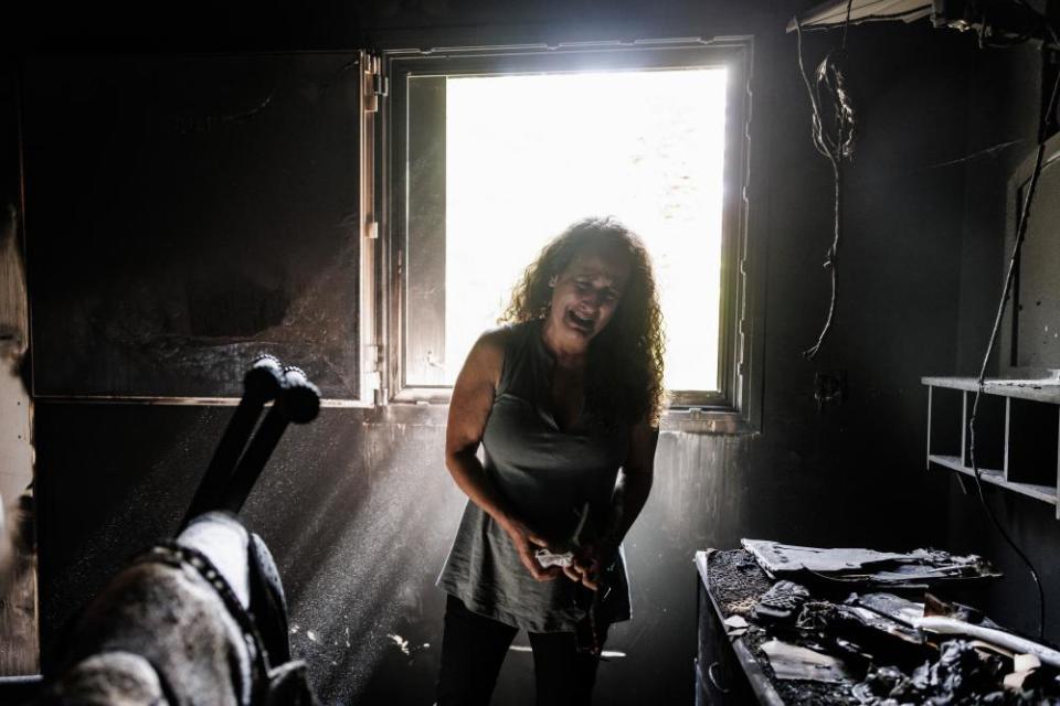 A kibbutz resident cries in a burnt-out home