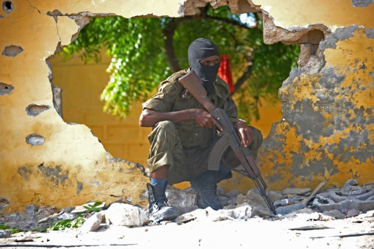 A Somali soldier stands guard next to the site where Al Shebab militants carried out a suicide attack against a military intelligence base in Mogadishu on June 21, 2015