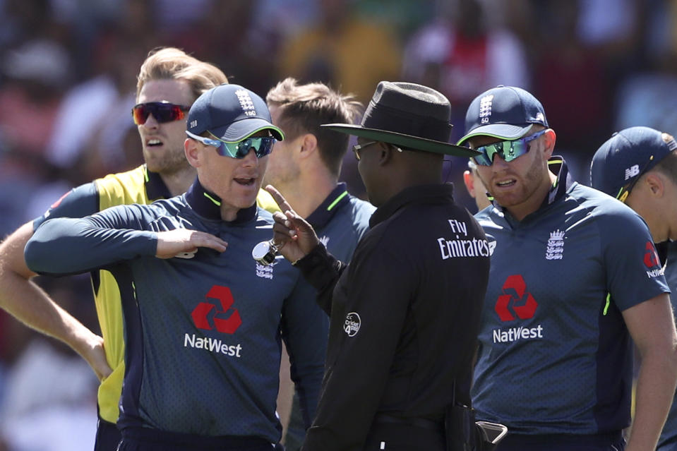 England's captain Eoin Morgan, left, talks to umpire Nigel Duguid during the fifth One Day International cricket match against West Indies at the Daren Sammy Cricket Ground in Gros Islet, St. Lucia, Saturday, March 2, 2019. (AP Photo/Ricardo Mazalan)