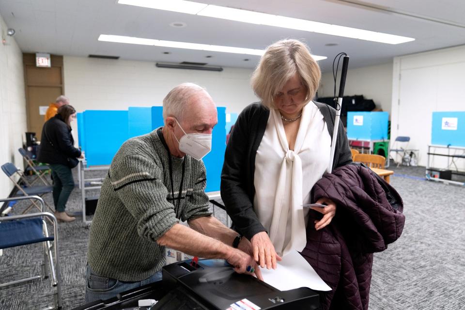 Patti Chang, who is blind, receives help from poll worker Bruce Mocking to vote in the Chicago mayoral runoff election at the Roden Branch of the Chicago Public Library Wednesday, March 22, 2023, in Chicago.