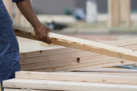 In this March 16, 2021 photo, a workman arranges a beam on a frame at a new housing site in Madison County, Miss. Rising costs and shortages of building materials and labor are rippling across the homebuilding industry, which accounted for nearly 12% of all U.S. home sales in July. Construction delays are common, prompting many builders to pump the brakes on the number of new homes they put up for sale. As building a new home gets more expensive, some of those costs are passed along to buyers. (AP Photo/Rogelio V. Solis)