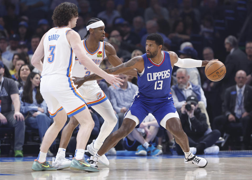 Feb 22, 2024; Oklahoma City, Oklahoma, USA; LA Clippers forward Paul George (13) moves the ball against Oklahoma City Thunder guard Shai Gilgeous-Alexander (2) and guard <a class="link " href="https://sports.yahoo.com/nba/players/6548/" data-i13n="sec:content-canvas;subsec:anchor_text;elm:context_link" data-ylk="slk:Josh Giddey;sec:content-canvas;subsec:anchor_text;elm:context_link;itc:0">Josh Giddey</a> (3) during the first quarter at Paycom Center. Mandatory Credit: Alonzo Adams-USA TODAY Sports