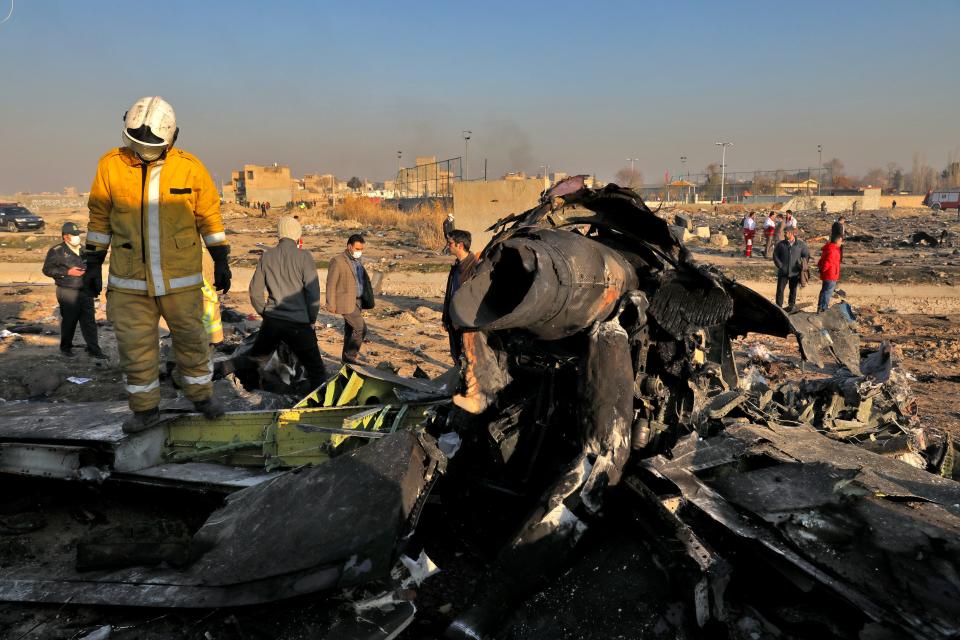 Rescue workers search the scene where a Ukrainian plane crashed in Shahedshahr, southwest of the Iranian capital, Tehran, on Jan. 8. The plane carrying more than 170 people crashed shortly after takeoff from Tehran's main airport, killing all onboard.