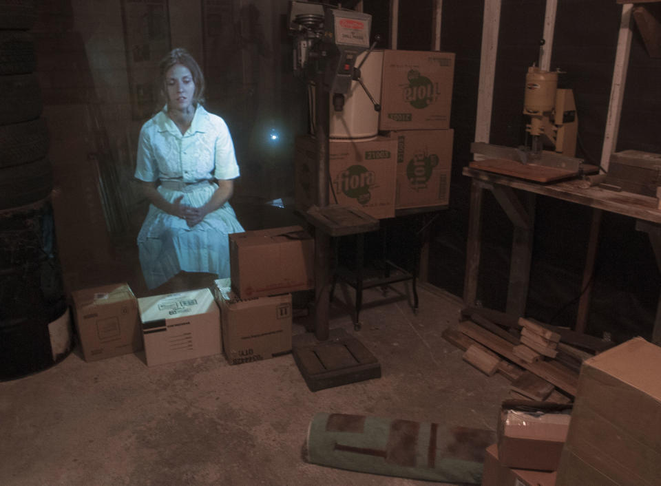 CORRECTS DATE OF MUSEUM OPENING TO NOV. 6 - In this Oct. 29, 2013 photo, an image of an actress portraying Marina Oswald, wife of Lee Harvey Oswald, is projected in the garage of the Ruth Paine House Museum, in Irving. The museum in the small, two-bedroom home that once belonged to Ruth Paine, who had befriended Marina and let her live there with her two daughters, will open Wednesday, Nov. 6, 2013. (AP Photo/Rex C. Curry)