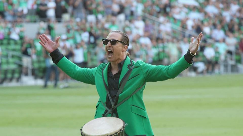 matthew mcconaughey screaming at the crowd while banging on a drum