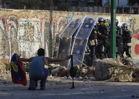 Un opositor al Gobierno de Nicolás Maduro se enfrenta a unos policías en la plaza Altamira de Caracas, mar 5 2014