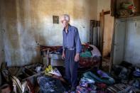 FILE PHOTO: Vassilis Tsatsarelis, 80, stands among debris and his belongings at his damaged house, in the aftermath of Storm Daniel, in the village of Metamorfosi