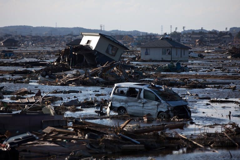 Debris and cars sit in a former rice field flooded by the tsunami and slowly drained using mechanical pumps in Higashimatsushima, Miyagi prefecture. Workers at Japan's crippled nuclear plant Sunday struggled to stop a radioactive water leak into the Pacific, as the government warned the facility may spread contamination for months