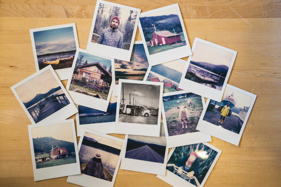 Collection of Polaroid photos displayed on a wooden table. 