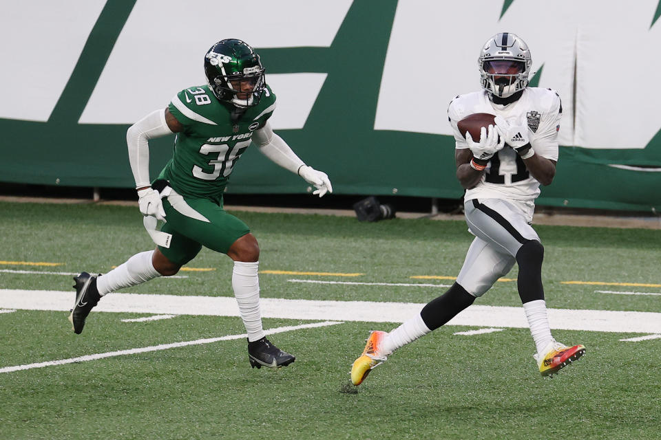 Henry Ruggs III #11 of the Las Vegas Raiders catches a touchdown pass to win the game as Lamar Jackson #38 of the New York Jets gives chase during the second half at MetLife Stadium.