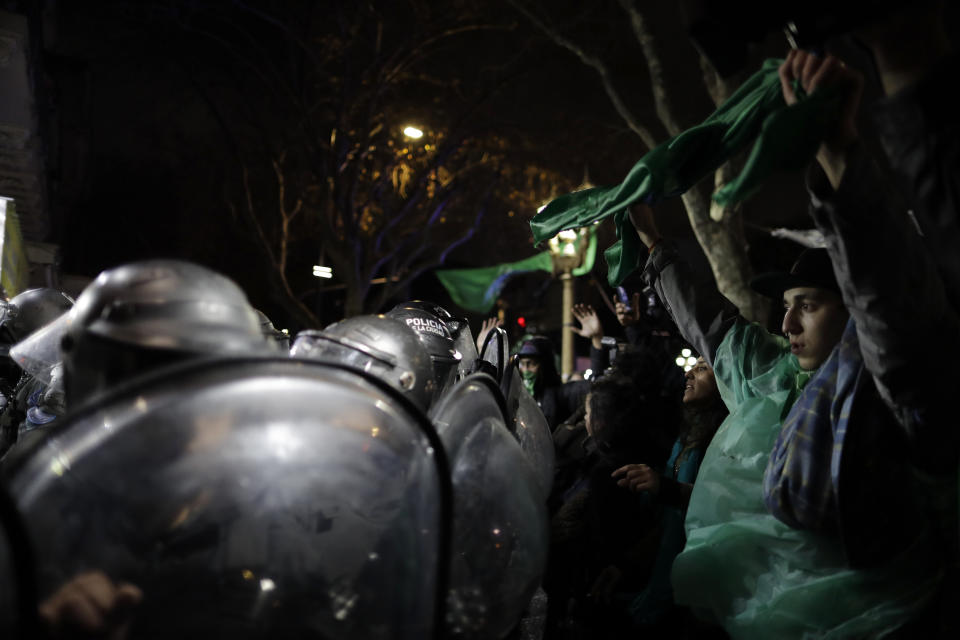 <p>Pro-choice activists stand with their arms up before police, outside Congress where clashes broke out after activists learned lawmakers voted against a bill that would have legalized elective abortion in the first 14 weeks of pregnancy, in Buenos Aires, Argentina, early Thursday, Aug. 9, 2018. (Photo: Natacha Pisarenko/AP) </p>