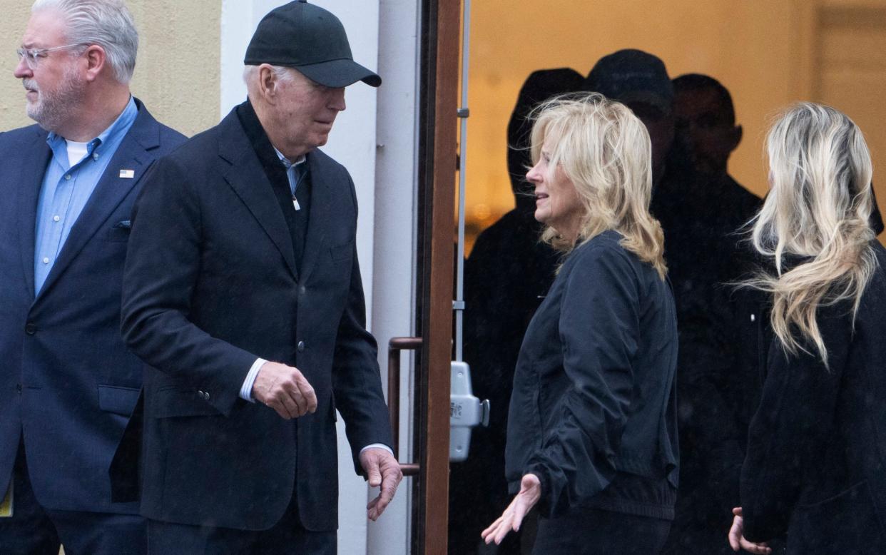 Joe Biden talks to his wife, Jill, as they walk from church after attending a Mass with family members on Monday