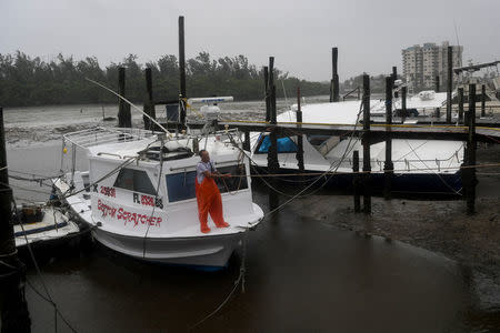 Local fisherman P.J. Pike attaches, in tropical storm wind and rain, additional mooring lines to his boat docked in Hurricane Harbor, as hurricane Irma approaches Fort Myers Beach, Florida, U.S., September 10, 2017. REUTERS/Bryan Woolston