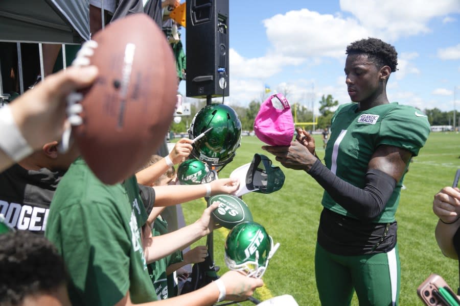 New York Jets’ Sauce Gardner, right, gives autographs and talks with fans after a practice at the NFL football team’s training facility in Florham Park, N.J., Sunday, July 30, 2023. (AP Photo/Seth Wenig)
