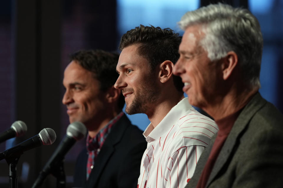 Newly acquired Philadelphia Phillies shortstop Trea Turner, center, smiles while speaking during his introductory news conference with president of baseball operations David Dombrowski, right, and general manager Sam Fuld, Thursday, Dec. 8, 2022, in Philadelphia. (AP Photo/Matt Slocum)