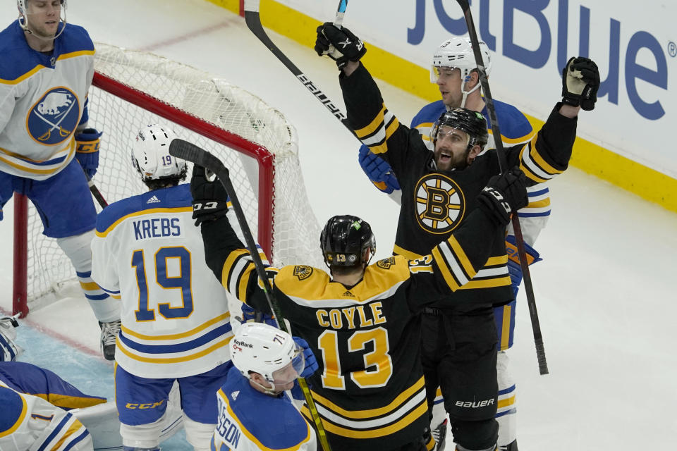 Boston Bruins left wing Nick Foligno (17) celebrates with teammate Charlie Coyle after scoring a goal against the Buffalo Sabres during the third period of an NHL hockey game, Saturday, Jan. 1, 2022, in Boston. (AP Photo/Mary Schwalm)