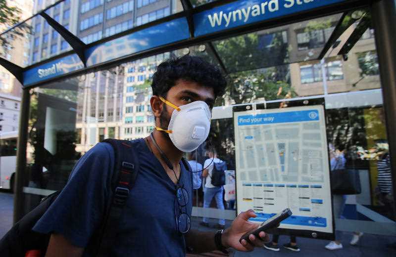 A man wears a face mask as he waits for a bus at Sydney's Wynyard Station.