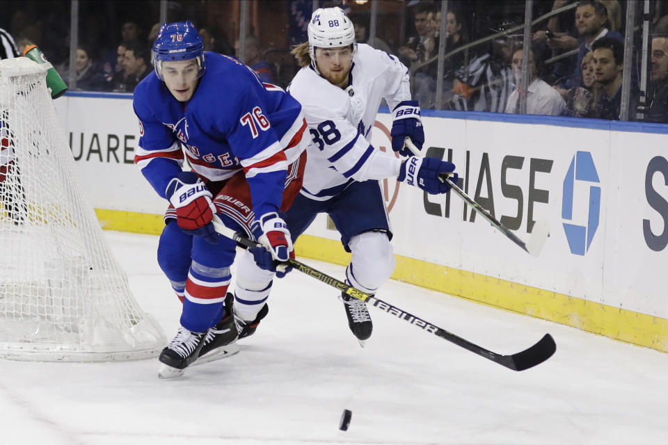 New York Rangers' Brady Skjei (76) fights for control of the puck with Toronto Maple Leafs' William Nylander (88) during the first period of an NHL hockey game Friday, Dec. 20, 2019, in New York. (AP Photo/Frank Franklin II)