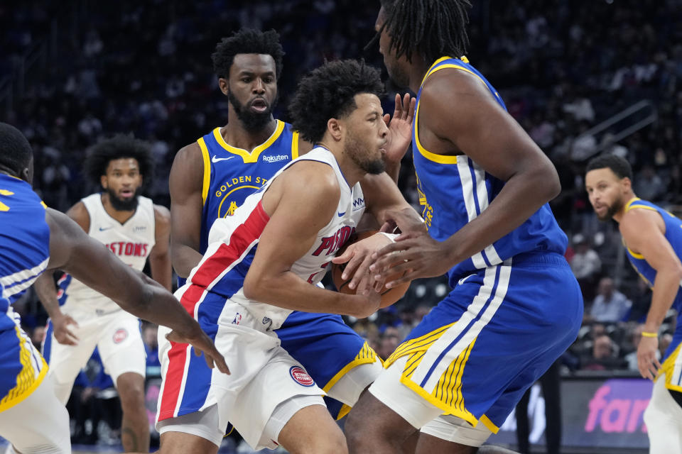 Detroit Pistons guard Cade Cunningham drives through the Golden State Warriors defense during the first half of an NBA basketball game, Monday, Nov. 6, 2023, in Detroit. (AP Photo/Carlos Osorio)
