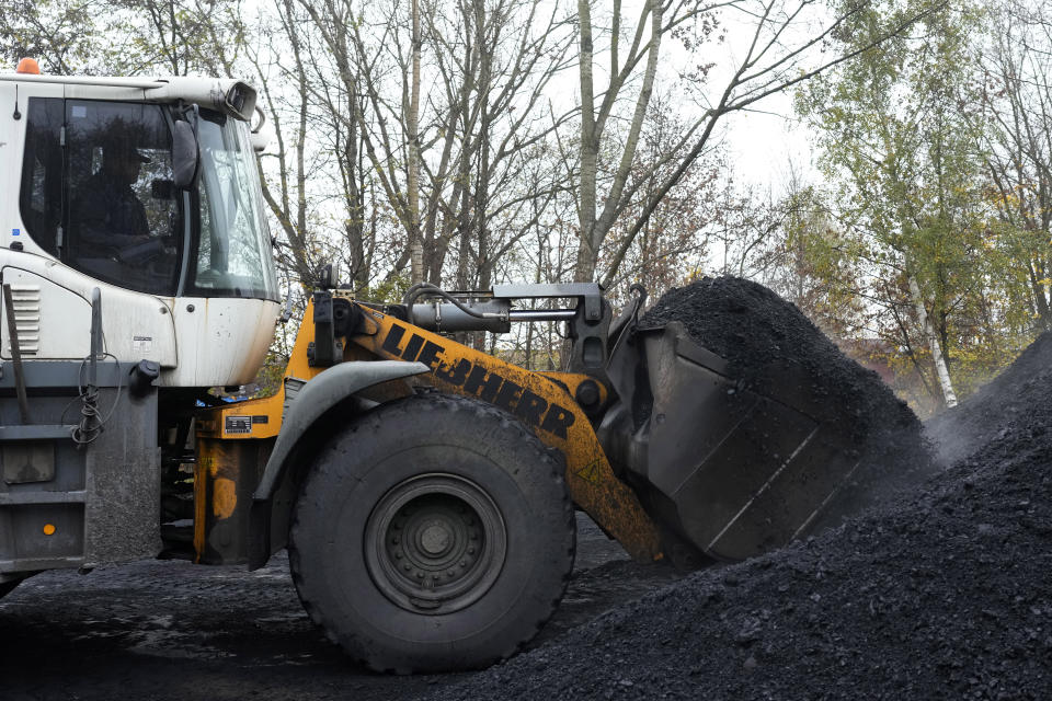 A worker moves coal at a selling point in Ostrava, Czech Republic, Friday, Nov. 11, 2022. High energy prices linked to Russia's war in Ukraine have paved the way for coal’s comeback, endangering climate goals and threatening health from increased pollution. (AP Photo/Petr David Josek)