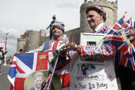 Royal fans John Loughery, left and Terry Hutt pose with flags and banners, outside Windsor Castle, in Windsor, south England, Tuesday, May 7, 2019, a day after Prince Harry announced that his wife Meghan, Duchess of Sussex, had given birth to a boy. The as-yet-unnamed baby arrived less than a year after Prince Harry wed Meghan Markle in a spectacular televised event on the grounds of Windsor Castle that was watched the world over. (AP Photo/Alastair Grant)