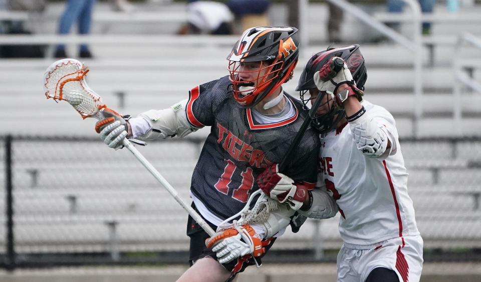 Mamaroneck's Luke Brennan (11) works against Rye's Joe Chai (2) during their 9-7 win in boys lacrosse at Rye High School. Thursday, April 18, 2024.