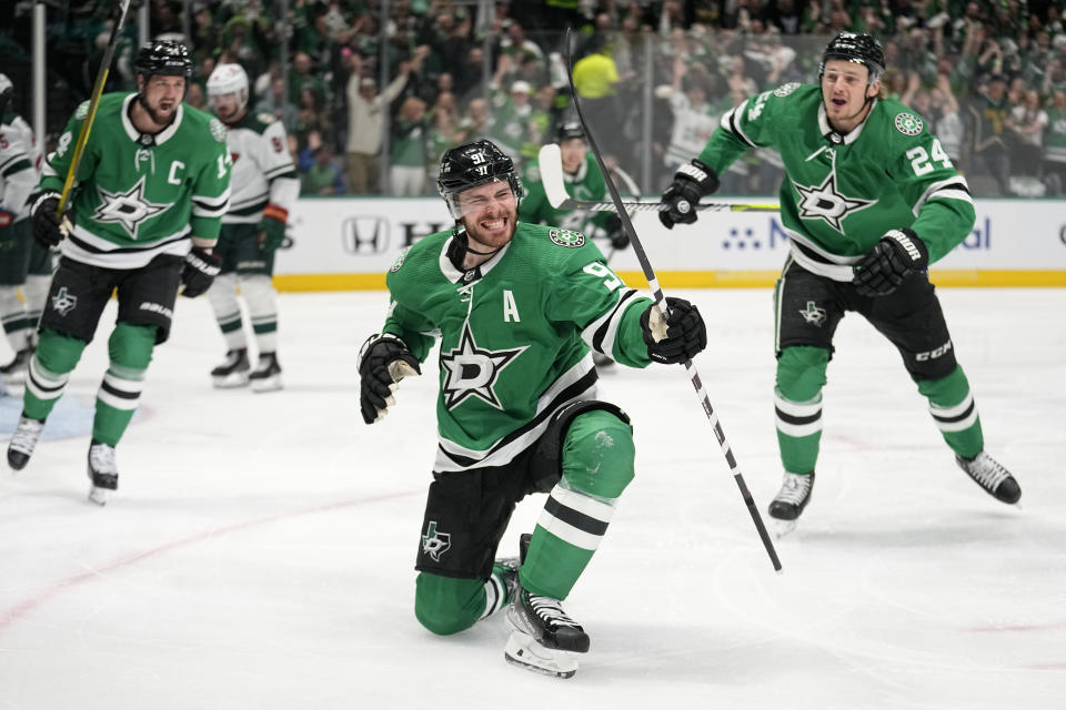 Dallas Stars center Tyler Seguin (91) celebrates with Jamie Benn, left, and Roope Hintz (24) after scoring against the Minnesota Wild during the first period of Game 5 of an NHL hockey Stanley Cup first-round playoff series Tuesday, April 25, 2023, in Dallas. (AP Photo/Tony Gutierrez)