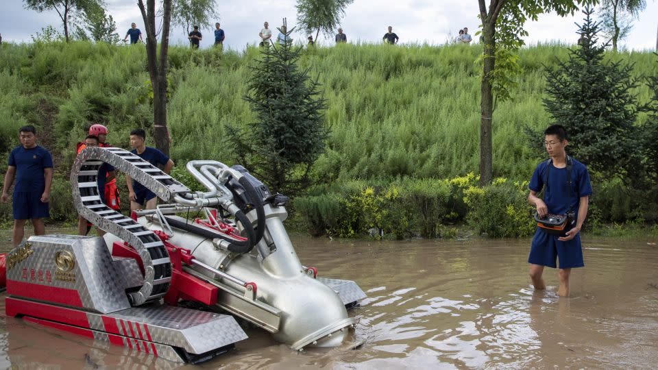 Firefighters operate a drainage machine near a village in the city of Mudanjiang in northeastern China's Heilongjiang province on August 5. - Zhang Tao/AP