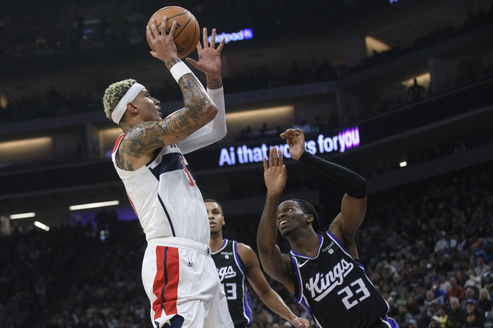 Washington Wizards forward Kyle Kuzma, left, drives to the basket over Sacramento Kings guard Keon Ellis (23) during the first quarter of an NBA basketball game in Sacramento, Calif., Monday, Dec. 18, 2023. (AP Photo/Randall Benton)