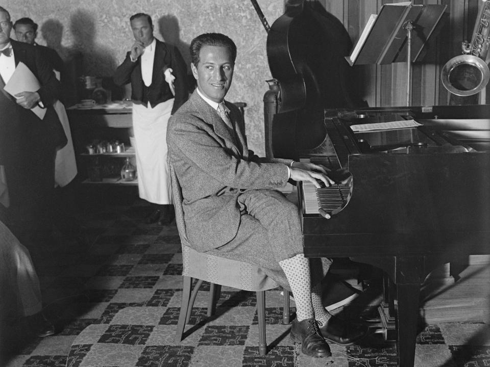 George Gershwin, foremost music composer, is seen here at the piano at the Deauville pool where he is vacationing