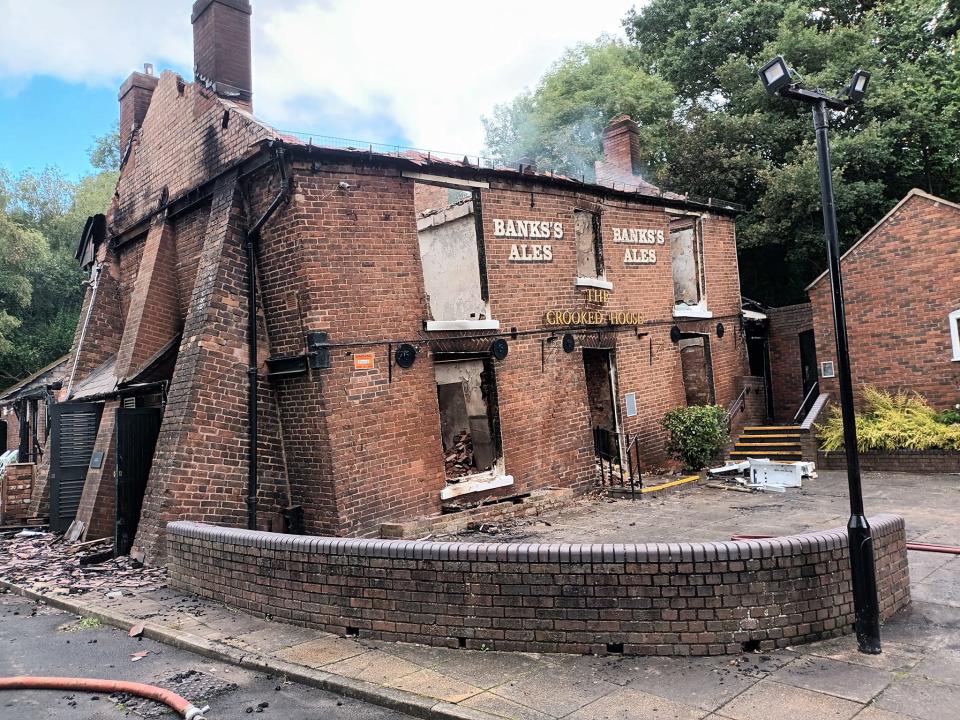 The remains of the Crooked House pub pictured on Sunday, the day after the fire... and the day before it was demolished. (PA)