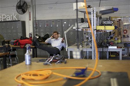 A man speaks on a mobile phone at TechShop in the South of Market neighborhood in San Francisco, California April 24, 2014. REUTERS/Robert Galbraith