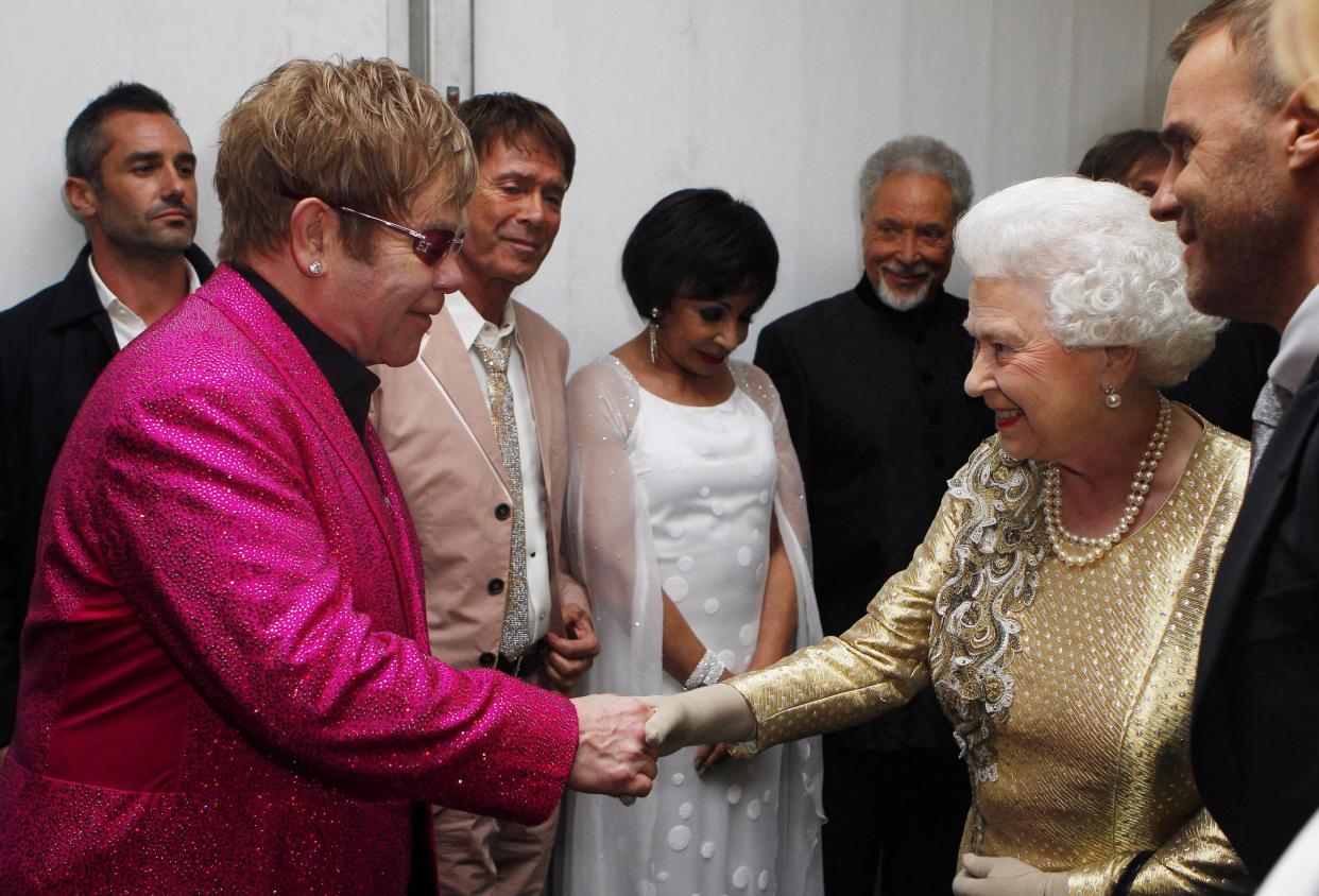 LONDON, ENGLAND - JUNE 04:  Queen Elizabeth II is introduced to Sir Elton John (L) backstage by Gary Barlow (R) after the Diamond Jubilee, Buckingham Palace Concert June 04, 2012 in London, England. For only the second time in its history the UK celebrates the Diamond Jubilee of a monarch. Her Majesty Queen Elizabeth II celebrates the 60th anniversary of her ascension to the throne. Thousands of well-wishers from around the world have flocked to London to witness the spectacle of the weekend's celebrations.  (Photo by Dave Thompson - WPA Pool/Getty Images)