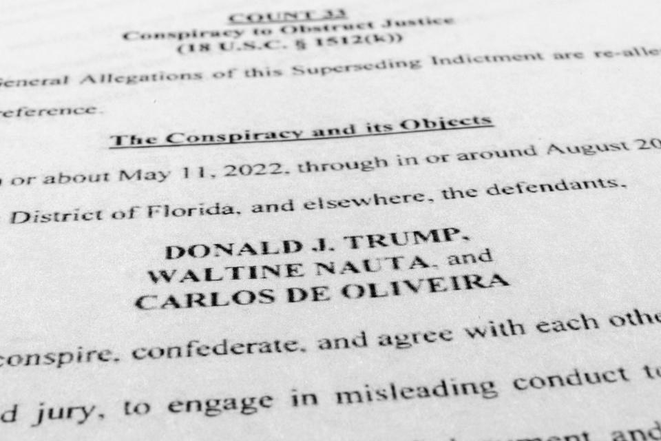 FILE - The updated indictment against former President Donald Trump, Walt Nauta and Carlos De Oliveira is photographed July 27, 2023. The federal judge overseeing the classified documents prosecution of Trump is expected to set a trial date during a court hearing on March 1, 2024. (AP Photo/Jon Elswick, File)