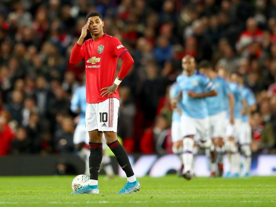 Marcus Rashford reacts after Manchester City's third goal: Getty