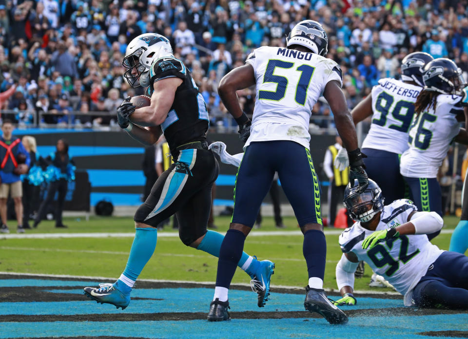 Carolina Panthers' Christian McCaffrey, left, runs for a touchdown past Seattle Seahawks' Barkevious Mingo (51) during the second half of an NFL football game in Charlotte, N.C., Sunday, Nov. 25, 2018. (AP Photo/Jason E. Miczek)