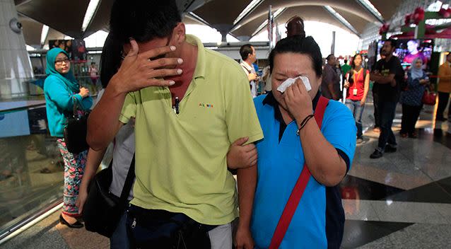 A woman wipes her tears after walking out of the reception center and holding area for family and friend of passengers aboard a missing Malaysia Airlines plane. Photo: AP