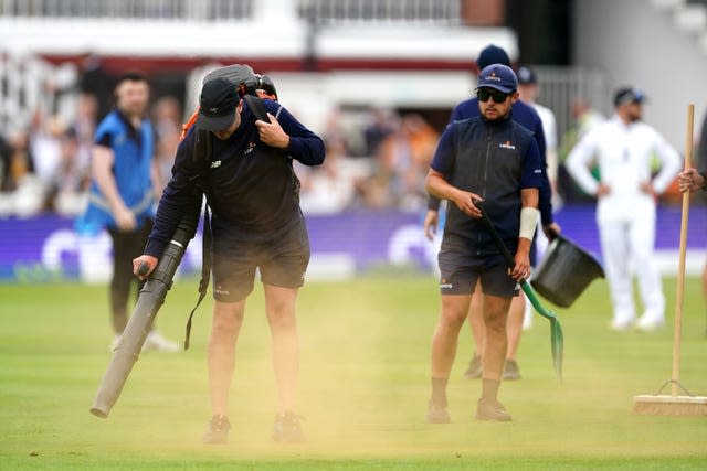 Ground staff cleaning up orange powder thrown by the protesters