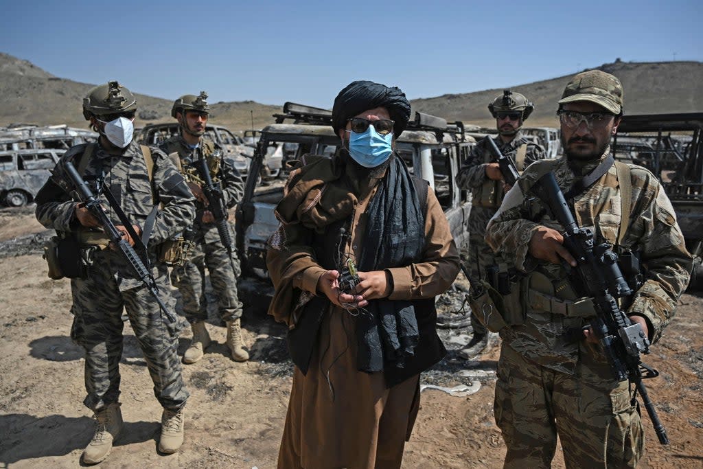 Members of the Taliban Badri 313 military unit stand beside damaged and discarded vehicles parked near the destroyed Central Intelligence Agency (CIA) base in Deh Sabz district northeast of Kabul (AFP via Getty Images)