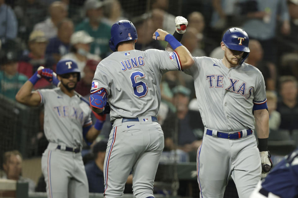 Texas Rangers' Josh Jung is greeted by Sam Huff after hitting a solo home run on a pitch from Seattle Mariners starting pitcher Robbie Ray during a baseball game, Tuesday, Sept. 27, 2022, in Seattle. Behind is Renger's Leody Taveras. (AP Photo/John Froschauer)