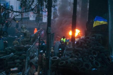 Anti-government protesters stand on fortifications erected against possible assaults by riot police in Kiev, January 28, 2014. REUTERS/Thomas Peter