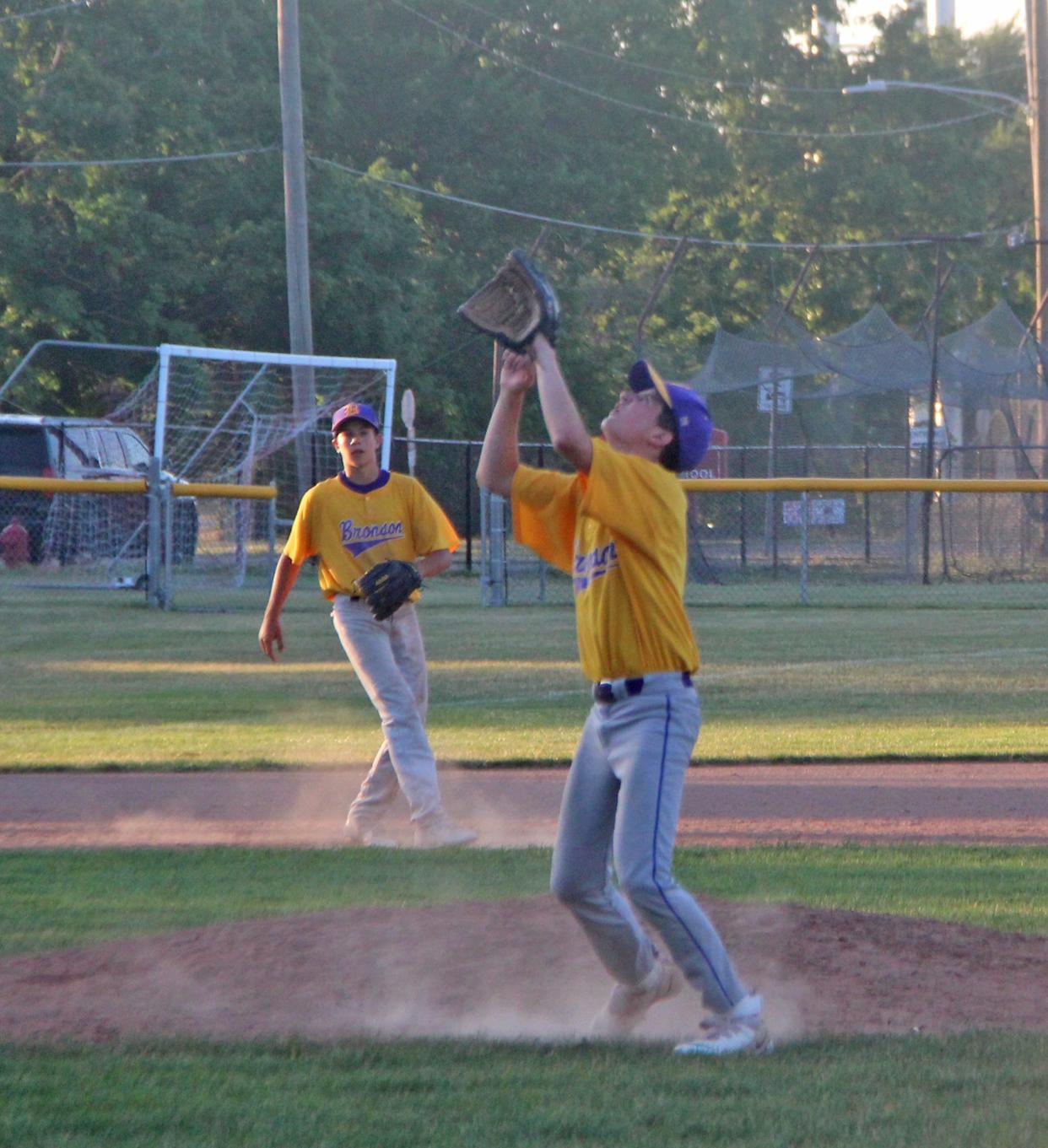 Bronson's Max Arver hauls in a fly ball while teammate Spencer Losinski looks on Wednesday in Mickey Mantle action