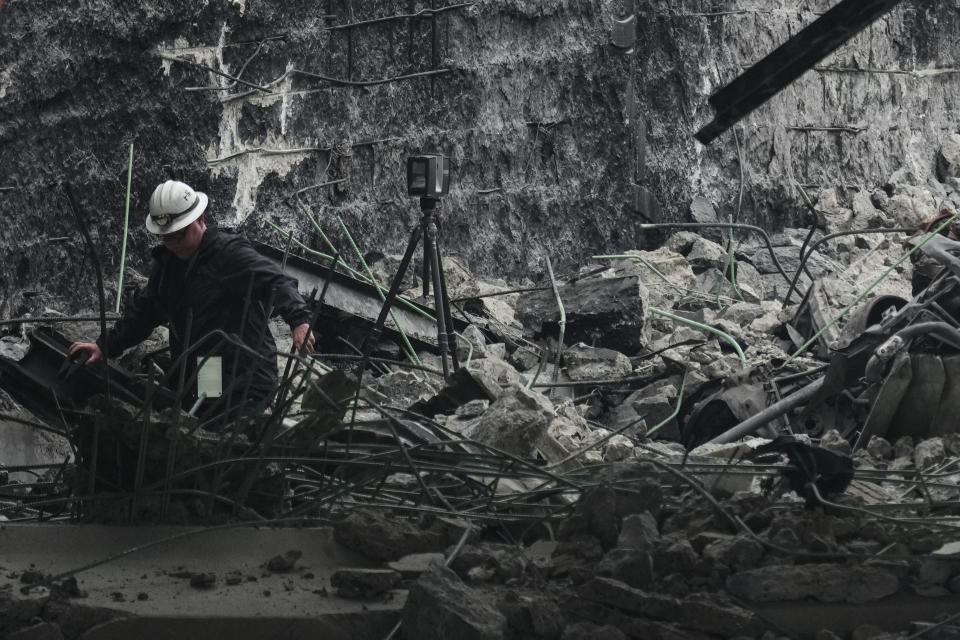 A investigator surveys the aftermath of an elevated section of Interstate-95 that collapsed, in Philadelphia, Monday, June 12, 2023. (AP Photo/Matt Rourke)