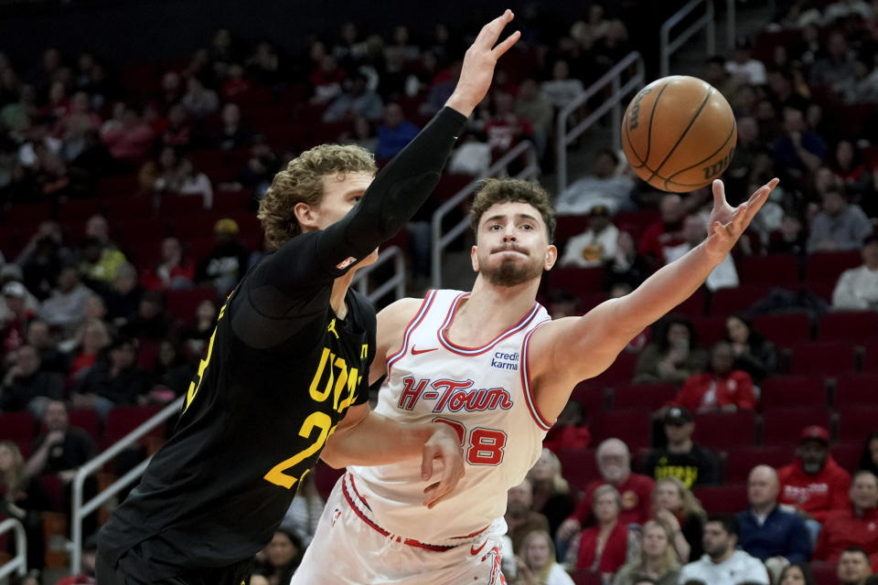 Houston Rockets center Alperen Sengun, right, and Utah Jazz forward Lauri Markkanen reach for a loose ball during the first half of an NBA basketball game Saturday, Jan. 20, 2024, in Houston. (AP Photo/Eric Christian Smith)