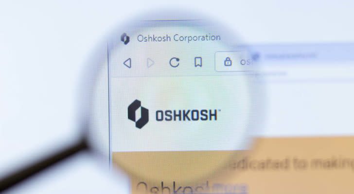 A magnifying glass zooms in on Oshkosh Corporation (OSK)'s homepage.