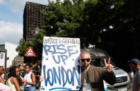 <p>A man holds u a placard near the remains of Grenfell Tower in London, Saturday, June 17, 2017. Police Commander Stuart Cundy said Saturday it will take weeks or longer to recover and identify all the dead in the public housing block that was devastated by a fire early Wednesday. (AP Photo/Kirsty Wigglesworth) </p>
