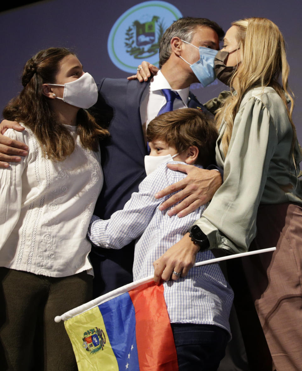 Venezuelan opposition leader Leopoldo Lopez kisses his wife Lilian Tintori with their son and daughter after a news conference in Madrid on Tuesday, Oct. 27, 2020. Prominent opposition activist Leopoldo López who has abandoned the Spanish ambassador's residence in Caracas and left Venezuela after years of frustrated efforts to oust the nation's socialist president is holding a news conference in Madrid. (AP Photo/Andrea Comas)