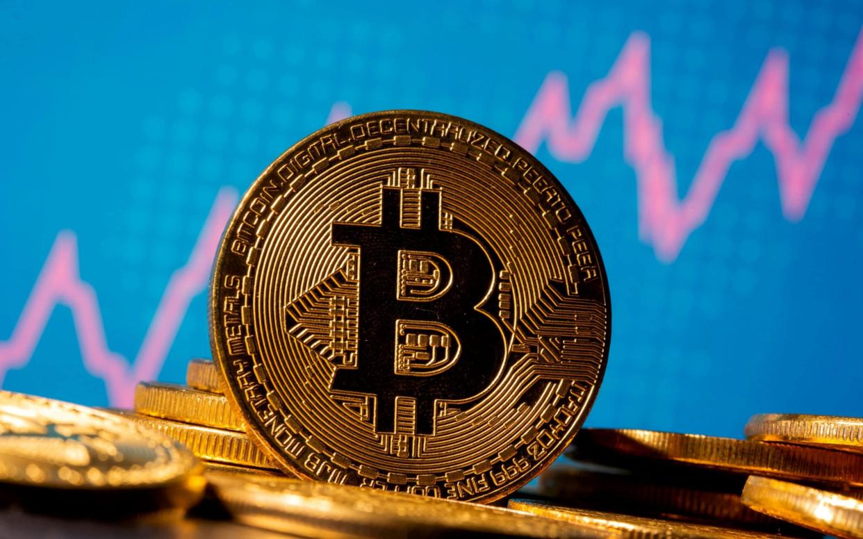 A representation of virtual currency Bitcoin is seen in front of a stock graph - REUTERS