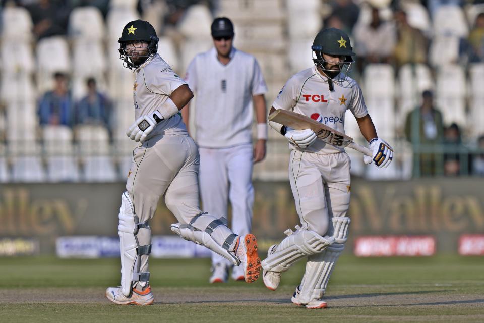 Pakistan's Imam-ul-Haq, left, and Saud Shakeel, right, run between the wickets during the third day of the second test cricket match between Pakistan and England, in Multan, Pakistan, Sunday, Dec. 11, 2022. (AP Photo/Anjum Naveed)